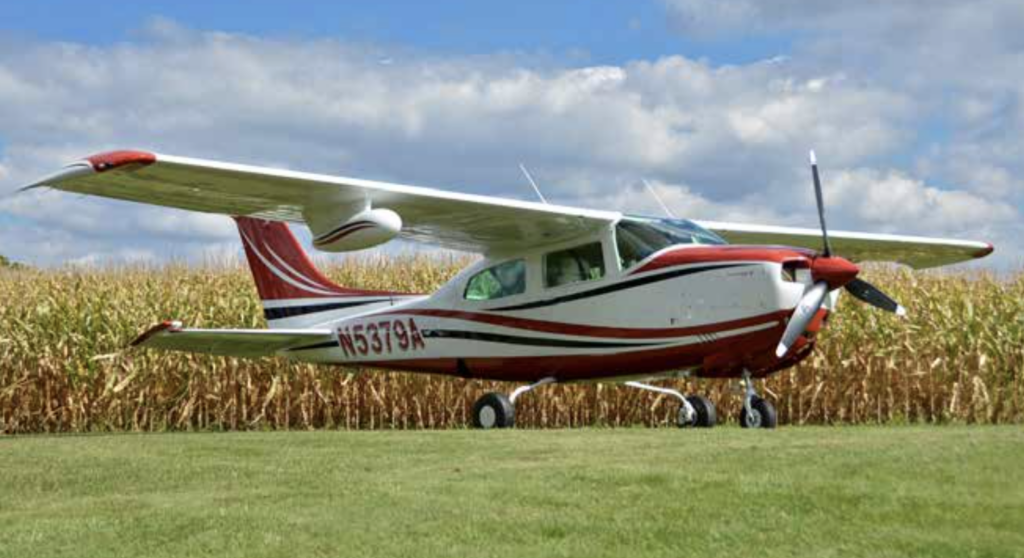 Cessna 210N on a grass strip.